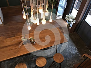 Hanging Light bulbs over long wooden coffee table photo