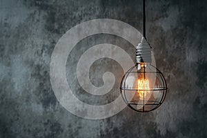 Hanging lightbulb industrial concept on cement background design