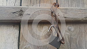 Hanging lock with iron chain from a wooden door