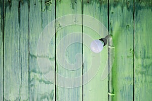 Hanging modern light bulb with green wooden planks