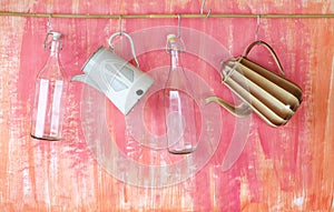 Hanging old glass bottles and vintage enamel coffee pots, copy space