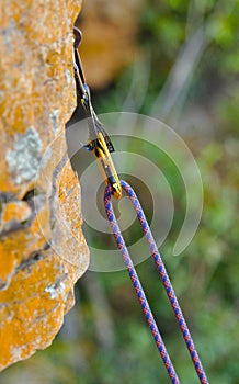 Climbing rope fixed to a wall by a yellow climbing carbine photo