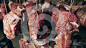 Hanging pieces of smoked spiced meat. Storage of meat products