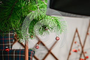 hanging red garland. against the background of gifts packed. Red ball Christmas ornament hanging on tree branch. Shining garland