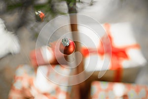 hanging red garland. against the background of gifts packed. Red ball Christmas ornament hanging on tree branch. Shining garland