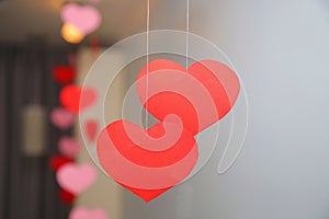 Hanging red hearts from paper