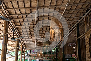 Hanging rope lamp with light bulb on wooden ceiling in cafe
