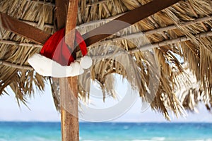 Hanging Santa Claus hat on palmy sunshade photo