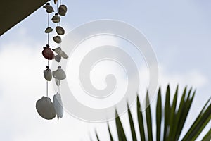 Hanging seashell wind chime mobile against sky background