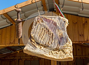 Hanging smoked homemade bacon and antique tin tube sausage stuffer in a street market