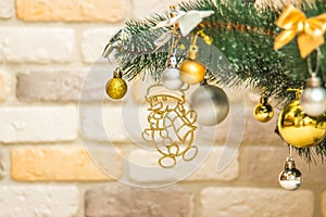 Hanging snowman decoration on the Christmas tree. Gold and silver baubles, multi-colored bows, animals, bells, lit garlands