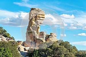 Hanging stone rock formation in the hills and cliffs of the arizona mountains and desert in afternoon sun with trees