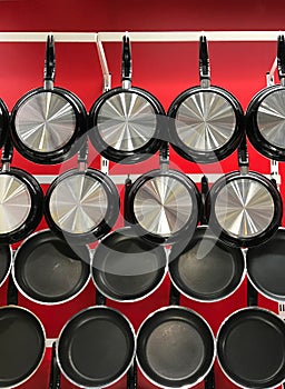 Hanging teflon pans on red wall