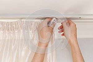 Hanging up curtain using pleat hooks.