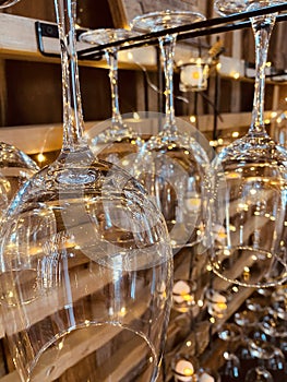 Hanging wine glasses with string lights in rustic bar setting