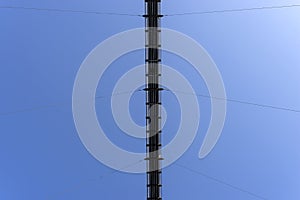 A hanging wooden bridge with steel ropes viewed from below against a blue sky.