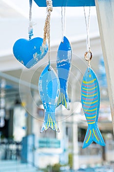 Hanging wooden fish figurines in a Greek beach cafe