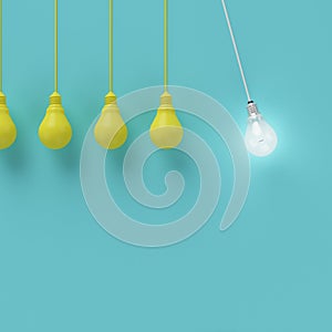 Hanging yellow light bulbs with glowing one different idea on light blue background