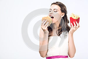 hangry young bride in wedding dress eating burger and french fries