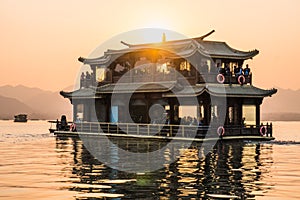 Hangzhou, China - November 9 2019: Beautiful sunset by the West Lake, a boat sailing on the lake