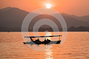 Hangzhou, China - November 9 2019: Beautiful sunset by the West Lake, a boat sailing on the lake