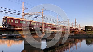 Hankyu train crossing a bridge over a river in Osaka, Japan.