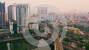 HANOI, VIETNAM - APRIL, 2020: Aerial panorama view of the railroad overpass and cityscape of Hanoi near lake.