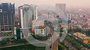 HANOI, VIETNAM - APRIL, 2020: Aerial panorama view of the railroad overpass and cityscape of Hanoi near lake.