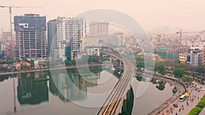 HANOI, VIETNAM - APRIL, 2020: Aerial panorama view of the railroad overpass and cityscape of Hanoi near lake.