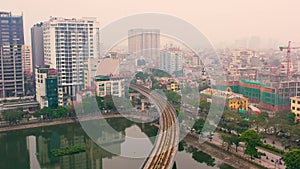 HANOI, VIETNAM - APRIL, 2020: Aerial panorama view of the railroad overpass and cityscape of Hanoi near lake.