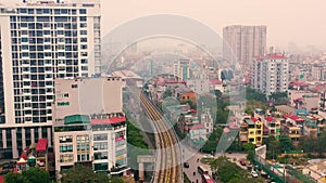 HANOI, VIETNAM - APRIL, 2020: Aerial panorama view of the railroad overpass and cityscape of Hanoi near lake.