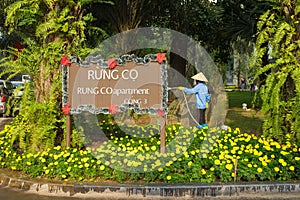 Hanoi, Vietnam - Jan 1, 2016: Aparment board sign with Asian woman watering a green and floral garden at Ecopark residential villa