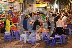 Hanoi, Vietnam - Nov 2, 2014: People drink beer on street at night in old quarter, center of Hanoi. Drinking beer on street is one