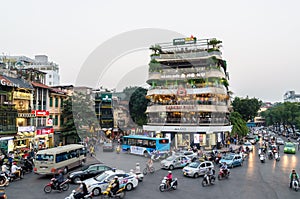 View of busy traffic in an intersection with many motorbikes and vehicles in Hanoi, capital of Vietnam.