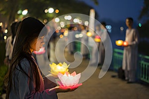 Hanoi, Vietnam - Oct 10, 2014: Buddhists hold flower garlands and colored lanterns for celebrating Buddha`s birthday organised at