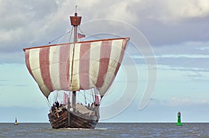 Hanseatic cog under sail with green and yellow buoy