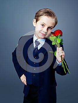 Hansome boy wearing a black suit with roses in his hands