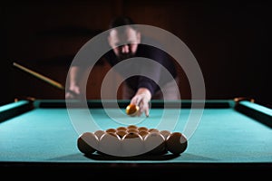 Hansome man playing billiards alone
