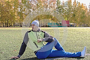 Hansome man wearing warm sportwear doing stretching exercises