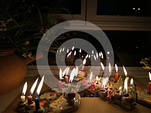 Hanukka candeles lit on a window shelf photo