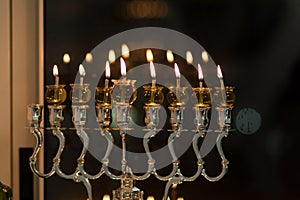 Hanukkah candles are lit in a silver-decorated