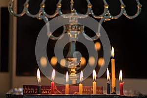 Hanukkah candles are lit in a silver-decorated