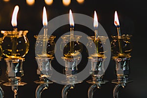 Hanukkah candles are lit in a silver-decorated