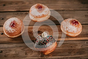 Hanukkah celebration concept. Close up view of tasty donuts with jam and menorah traditional candelabra.