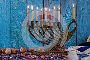 Hanukkah celebration with menorah with wooden dreidels and candles photo