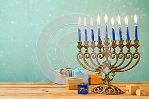 Hanukkah celebration with menorah on wooden table over bokeh background