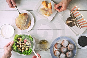 Hanukkah dinner with traditional dishes on the white wooden table