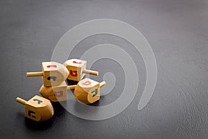 Hanukkah dreidels on gray table. Jewish holideys concept. Close up, space for text