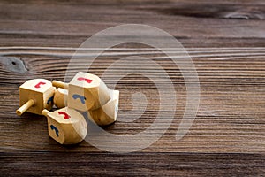 Hanukkah dreidels on wooden table. Jewish holideys concept. Close up, space for text