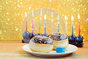 Hanukkah holiday sufganiyot with menorah on wooden table